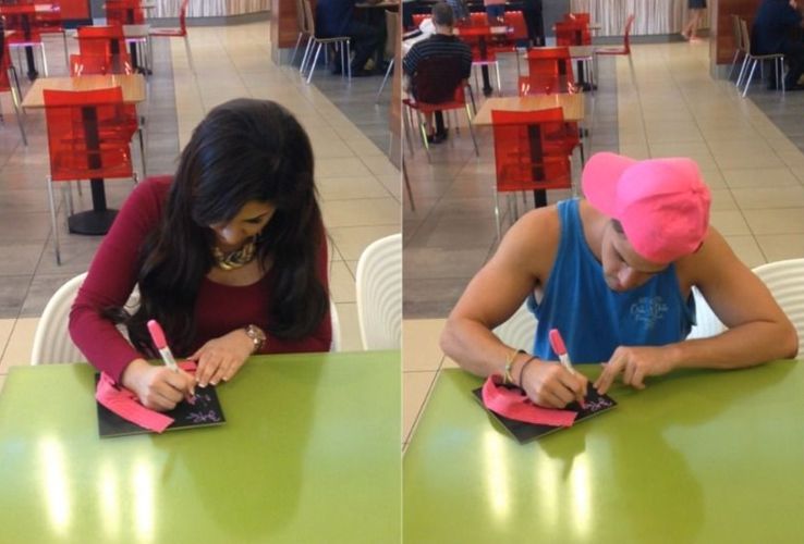 Victoria and Zach sign the hat frame